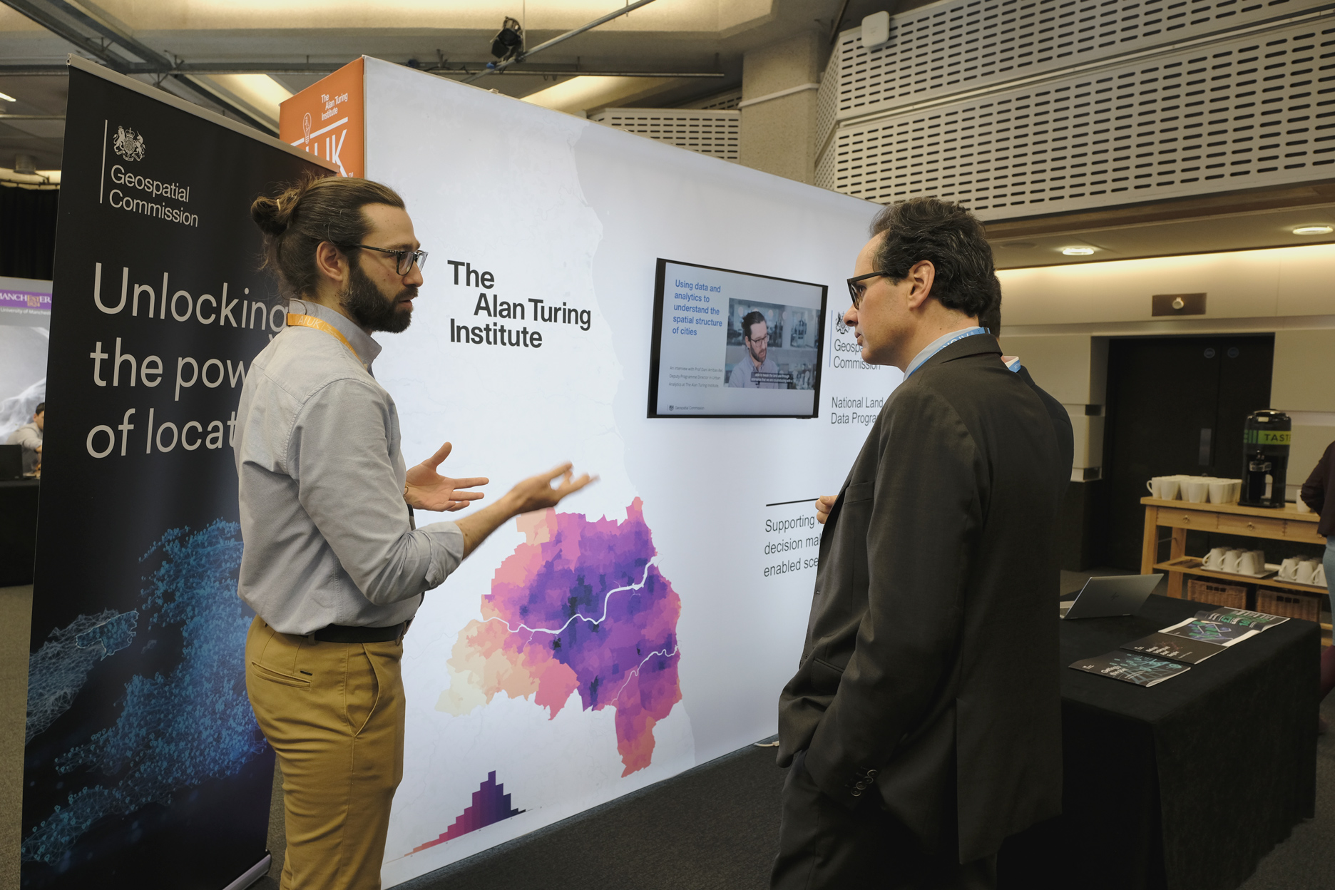 Viscount Camrose speaking to a researcher at an exhibition stand 