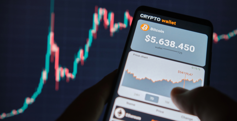 A man analyses the price chart for bitcoin in a smartphone app