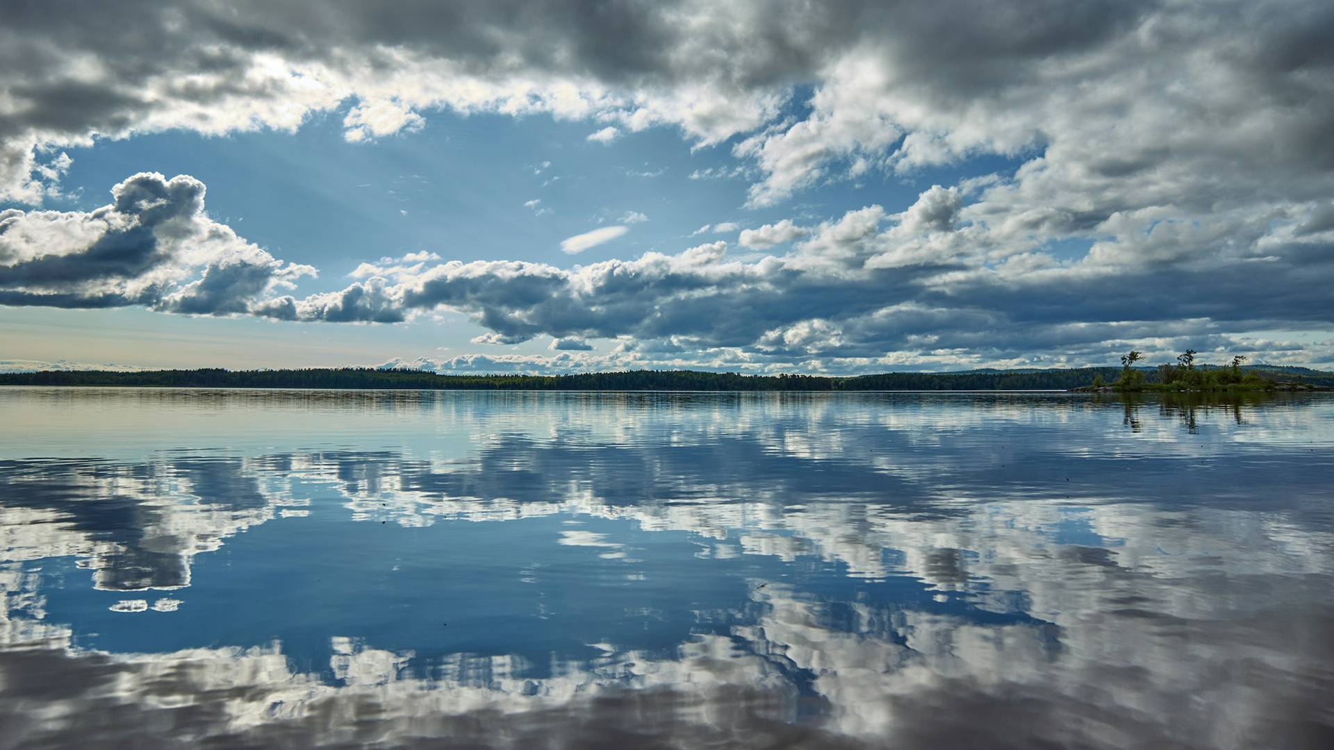 Cloudy blue sky reflected in large body of water